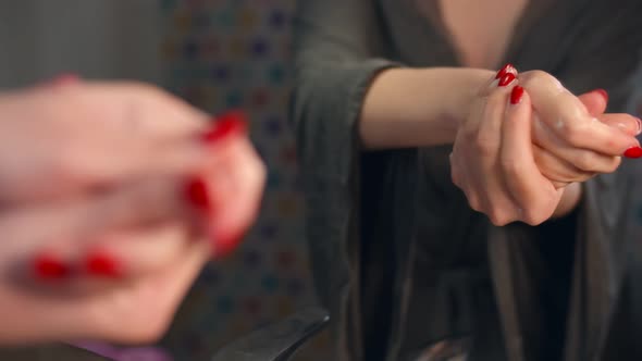 Close Up of Young Woman Rubbing Her Hands Using Nourishing Cream at Home