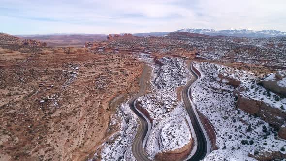 Flying backwards over road winding through the desert near Moab Utah