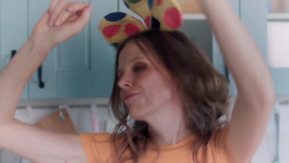 A Beautiful Woman in White Shorts is Relaxing at Home Dancing in the Kitchen