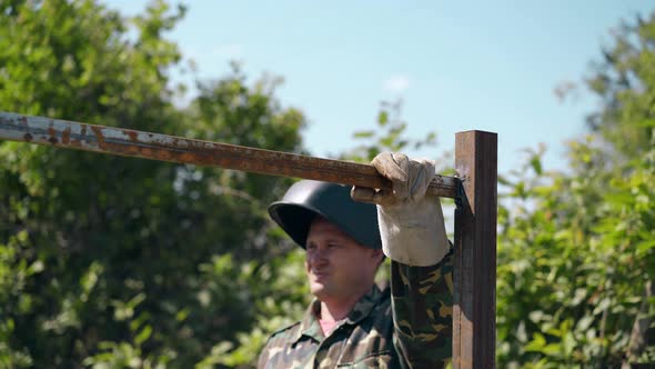 Builder Checks Fence Quality with Hammer and Hangs on Rail