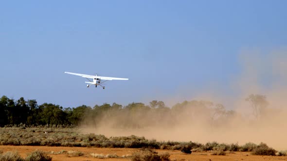Crop-duster taking off from a field in order to spread fertilizer or pesticides on a nearby agricult