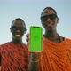 Extremely Happy Masai Tribe Men Showing Green Screen on Smartphone and Making Thumb Up Sign - VideoHive Item for Sale