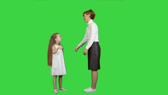 Beautiful Mother and Daughter Giving High Five and Smiling Each Other on a Green Screen, Chroma Key