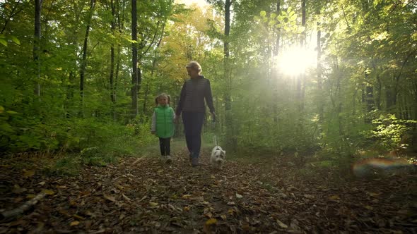 Woman with Little Daughter Walking the Dog in the Forest