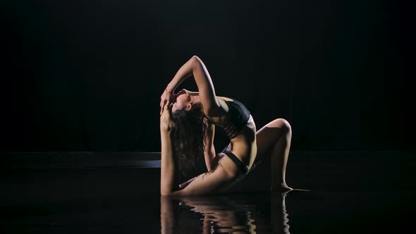 Slender Young Woman with Dark Hair Performs Yoga Exercises, Female Does Exercises for Stretching 