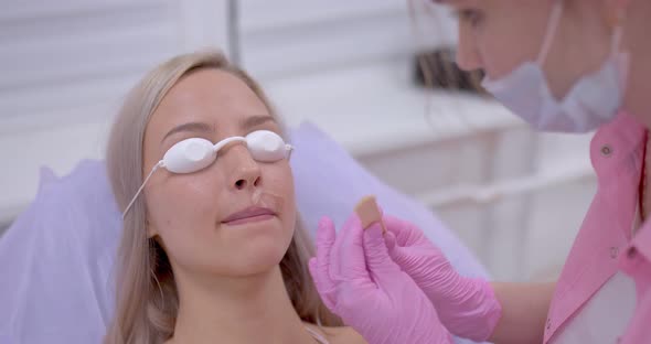 Cosmetologist Applies the Woman a Gel for Laser Hair Removal on Her Upper Lip Cosmetic Procedures in