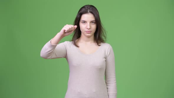Young Beautiful Woman Looking Upset and Giving Thumbs Down