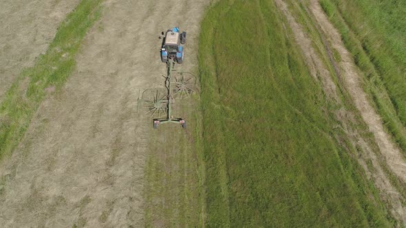 Tractor with Rake Tedders on the Farm Field