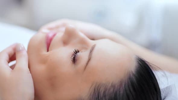 Closeup Face of Beautiful Young Woman with Pure Skin During Massage of Lower Chin Line