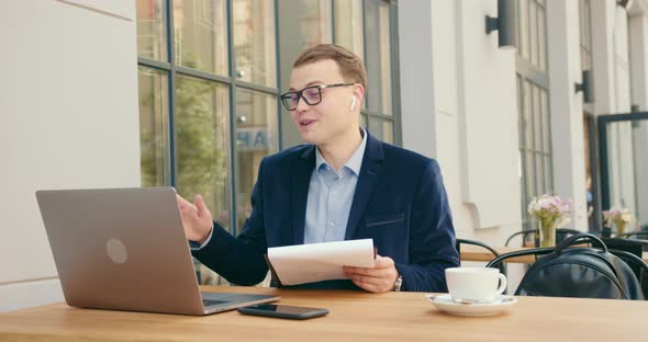 A Businessman Is Joyfully Discussing Business Issues at a Meeting Via a Video Call on a Laptop