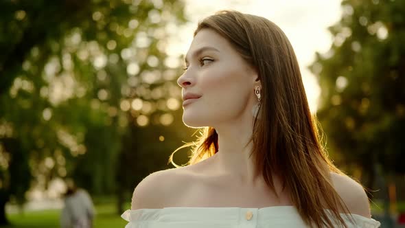 Close-up Portrait of a Charming Girl in the Rays of the Sunset