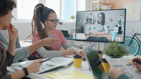 Creative Team Having Online Communication with Businesswoman Through Computer in Office