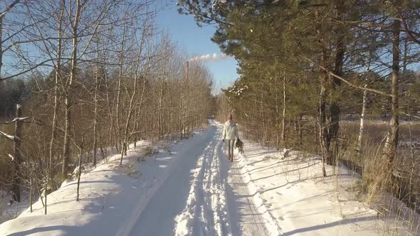 Upper Backside Woman with Pine Walks Along Winter Forest