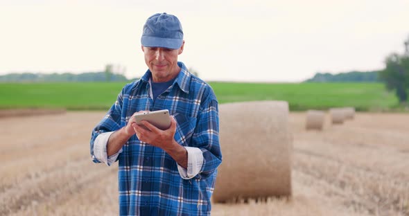 Farmer Using Digital Tablet While Examining Field