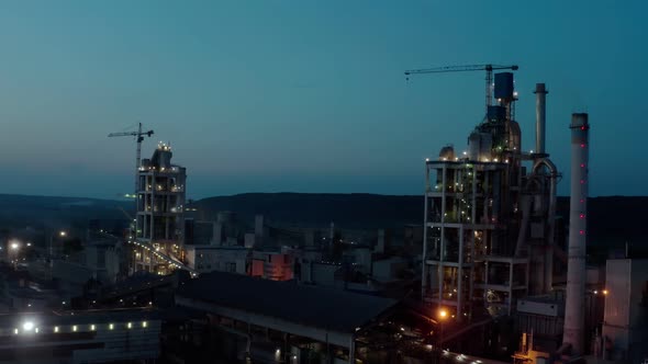 Cement Plant with High Factory Structure at Industrial Production Area at at Night with the Lights