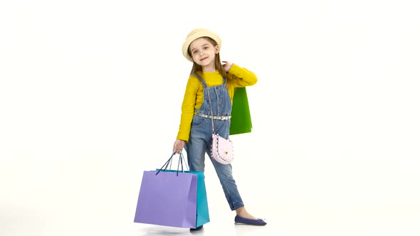 Little Girl Spinning Around Itself with Colorful Packages. White Background