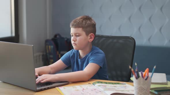 Portrait of a young boy teaching lessons online at a distance using laptop and internet via video