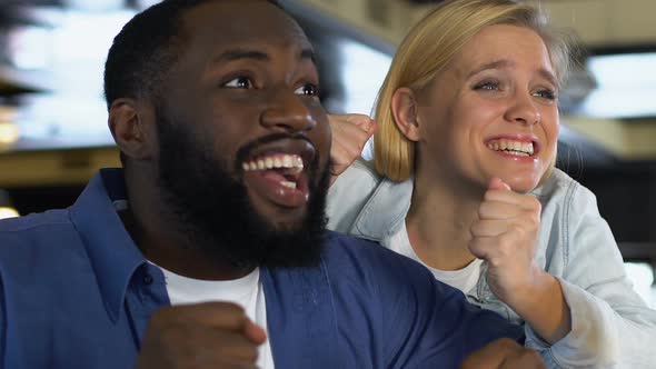 Man and Woman Giving High Five, Celebrating Favorite Sports Team Goal in Bar