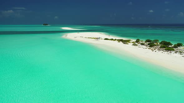 Wide angle birds eye clean view of a sandy white paradise beach and aqua blue ocean background in hi