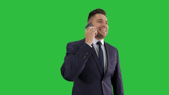 Businessman talking on mobile phone happily on a Green