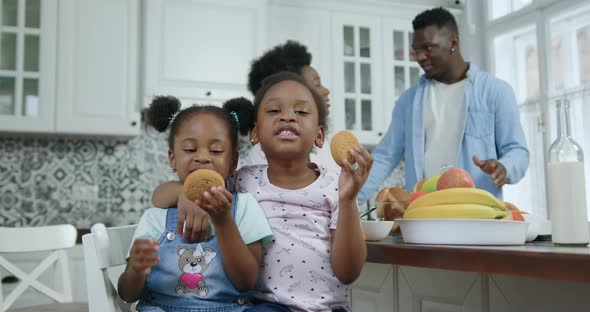 Small African American Girls Pose on Camera in Contemporary Kitchen