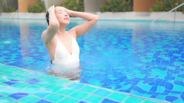 Young asian woman enjoy around outdoor swimming pool for leisure