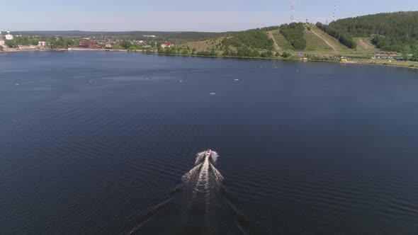 Aerial view of man ride a red and white jetski on the pond in provincial city 18