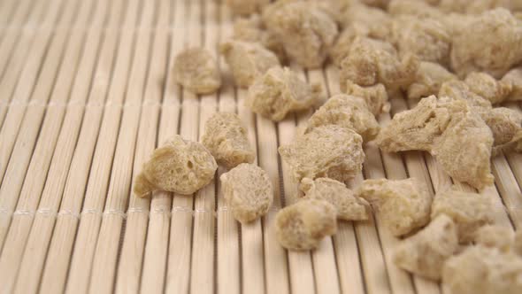 Flakes of textured dehydrated soybeans on a traditional bamboo mat