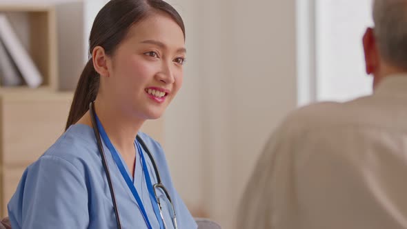 Old patient visits female doctor at clinic medical work writing prescription. Asian doctor and patie