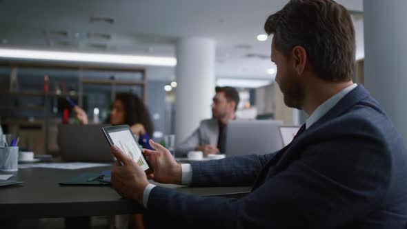 Happy Businessman Looking Tablet Searching Net with Multiracial Team in Office