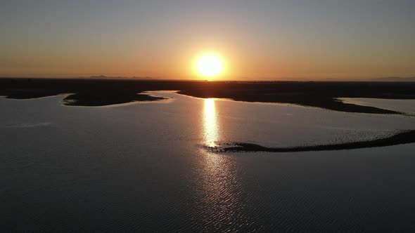 Drone Image of Sunrise Over Lake Reflected in Water