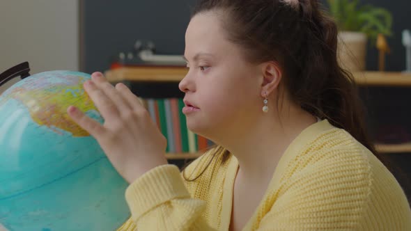 Girl with Down Syndrome Examining Globe