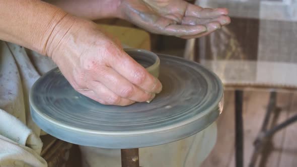Craftsman Creating Cup on Pottery Wheel in Slow Motion