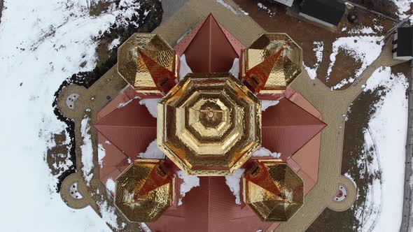 Aerial Top View on Ukrainian Church with Golden Domes in Carpathian Village in Winter alt