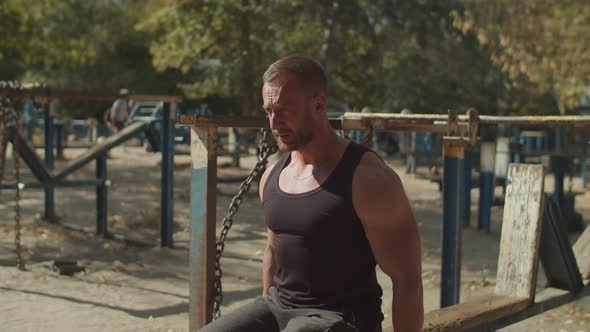 Athletic Man Doing Biceps Curl in Seated Position