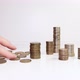 A woman's hand places coins on the table and counts them. Investment concept. Metallic currency - VideoHive Item for Sale