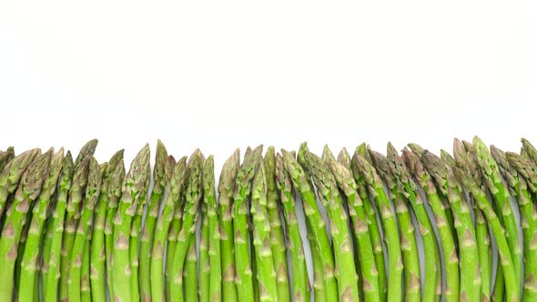 Green asparagus on white background, sliding shot