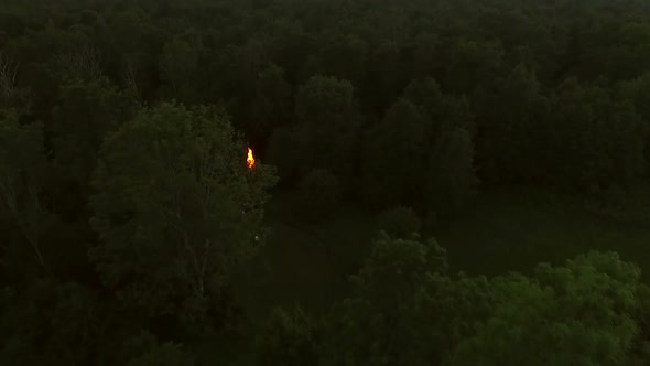 Aerial view of a campfire in the forest at sunset in Estonia.