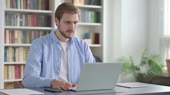 Man Reacting to Loss While Using Laptop