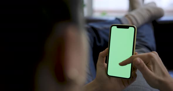 Close up shot of a woman using a smart phone with green screen