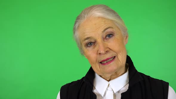 An Elderly Woman Talks to The Camera with A Smile