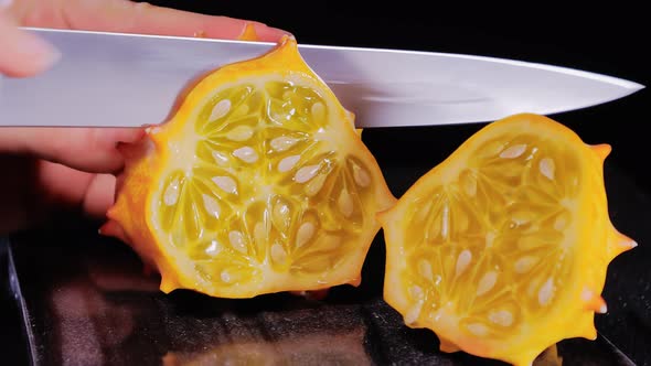 Female Hands Cutting African Horned Melon
