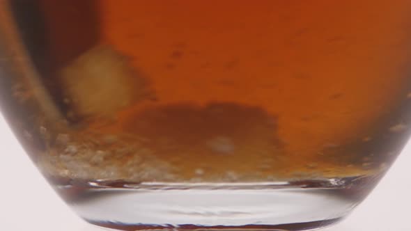 Closeup. Undissolved Sugar at the Bottom Glass Cup with Tea