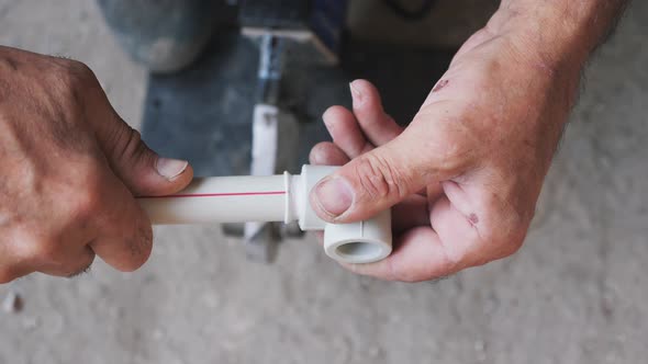 Plumber with soldering iron solders plastic metal tubes