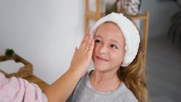 Woman Helping Daughter To Apply Creme on Face