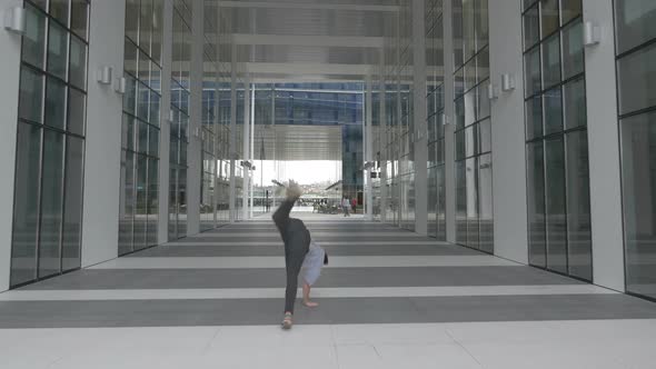 Traceur rolling and jumping near an office building