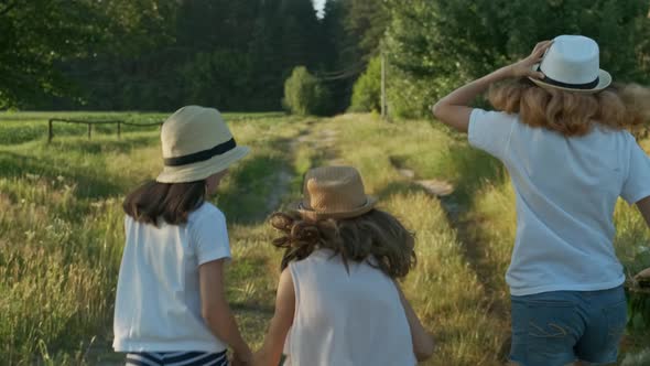 Children Three Girls in Hats Holding Hands Walking Back Along Rural Country Road