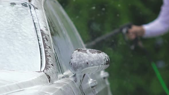 Car Wash Business Employee Cleaning Foamy Auto, Sprinkling Clear Water on Cabin