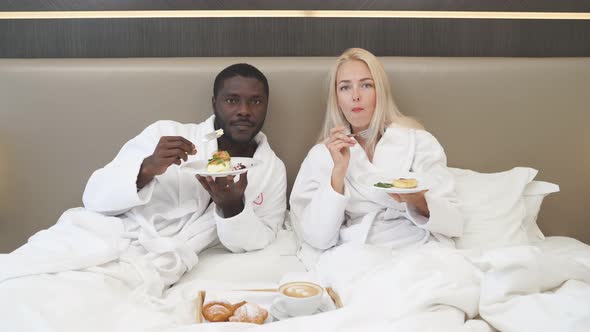 Funny Couple Watch Tv and Have Meal in Hotel