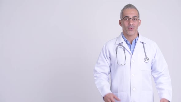 Happy Persian Man Doctor Showing Something Against White Background